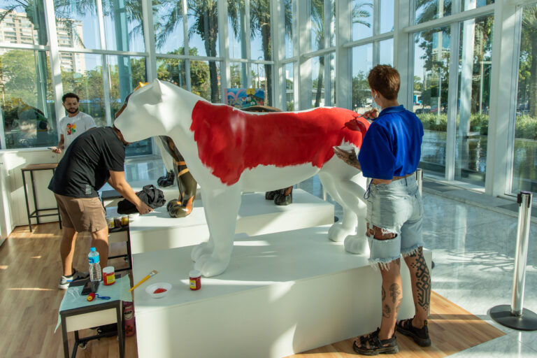 Artista pintando escultura de onça-pintada