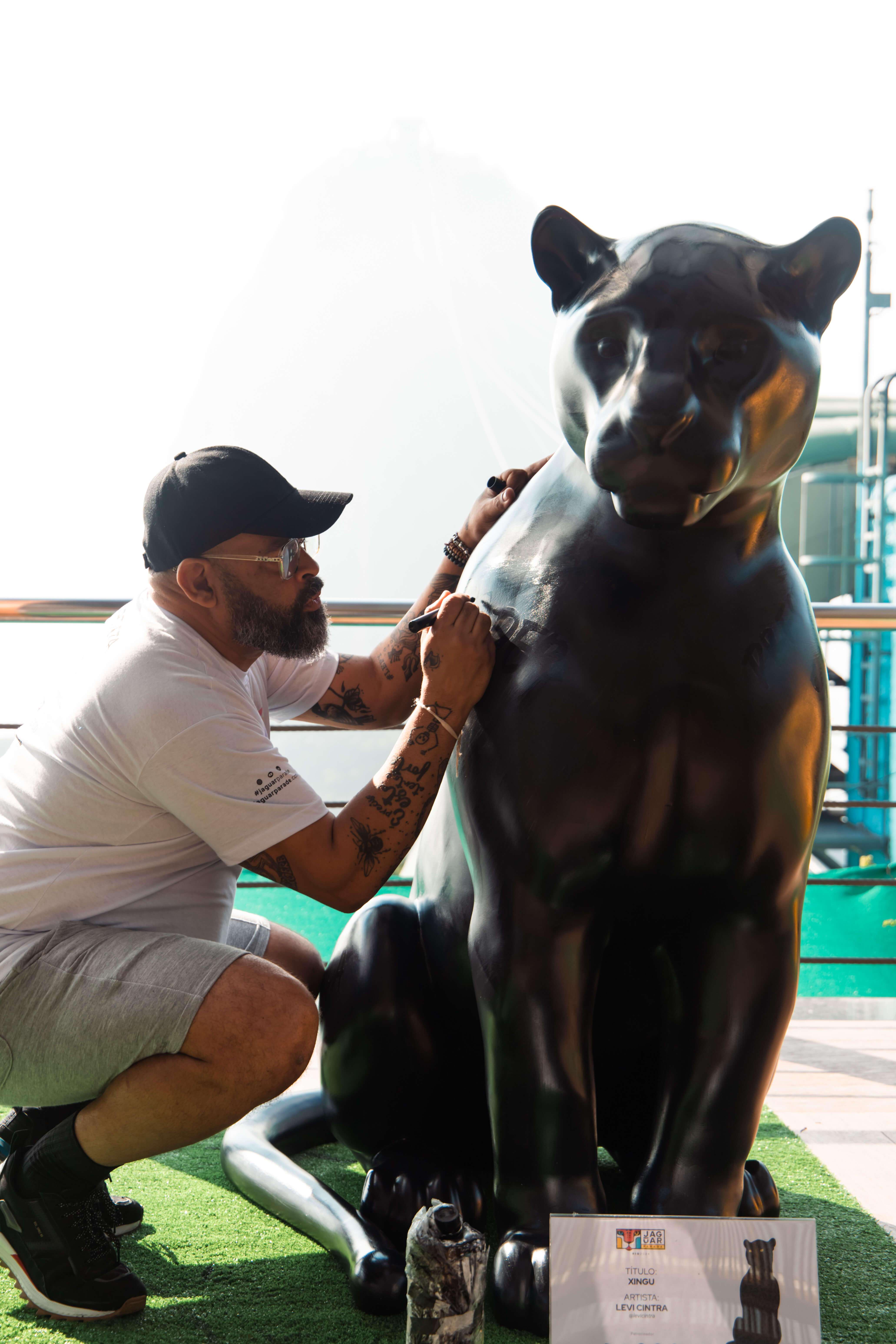 Artista pintando escultura de onça-pintada na Jaguar Parade